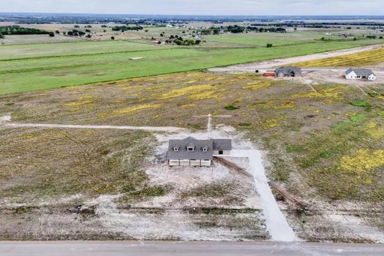 Aerial view of the home and the surrounding open land
