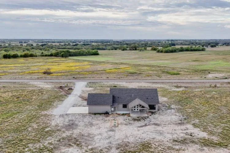 Wide aerial view of the home and neighboring land