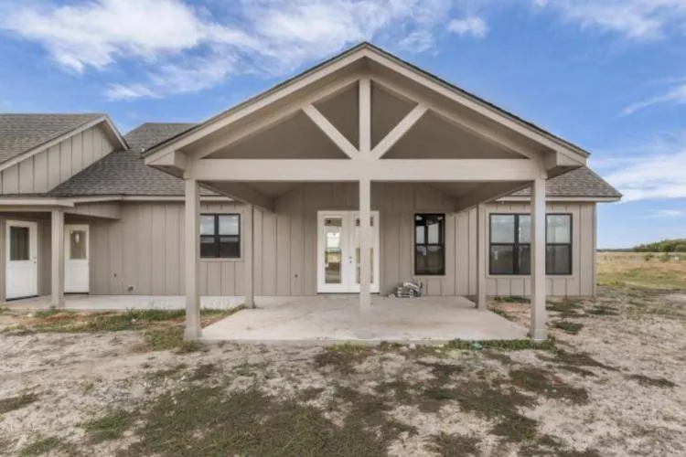 Covered back patio with gabled roof and exposed beams, French doors to the dining area