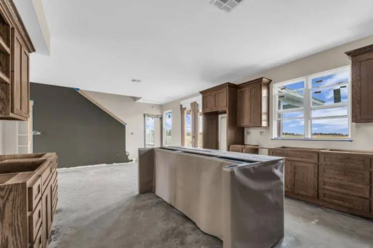 Dark olive kitchen island set against provincial-stained cabinets