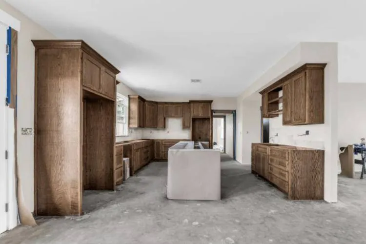 Kitchen with provincial-stained cabinetry and a center island during construction