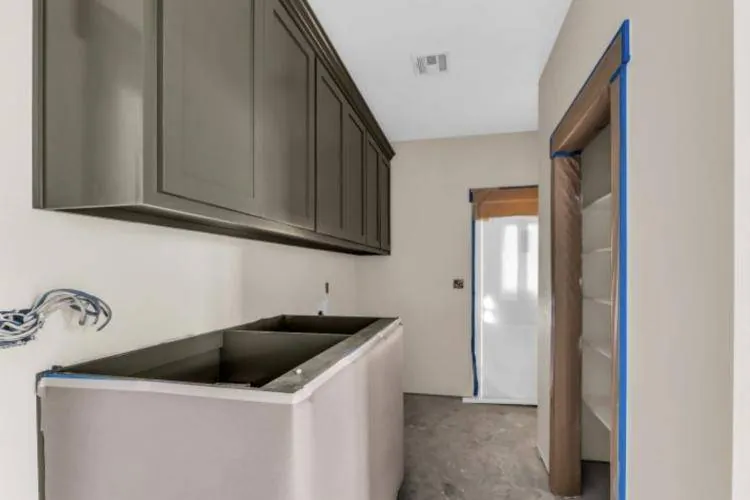 Utility room with dark olive upper cabinets